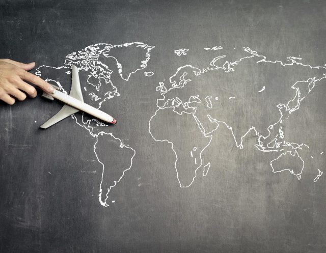 miniature airplane and hand of person over drawn map